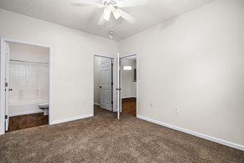 Spacious Carpeted Bedroom With Ceiling Fan
